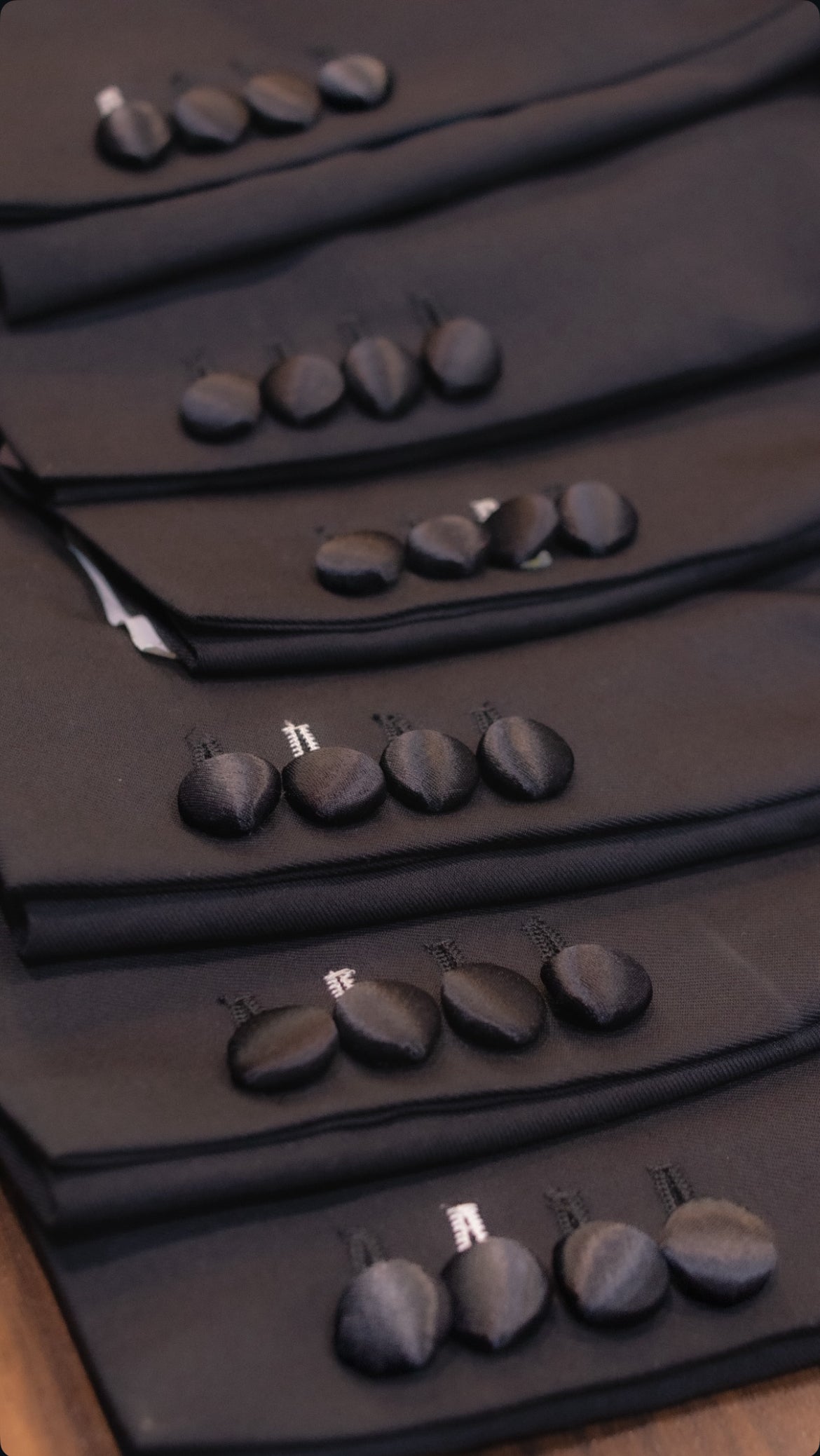 Black fabric-covered tuxedo buttons on tailored dinner jacket cuffs