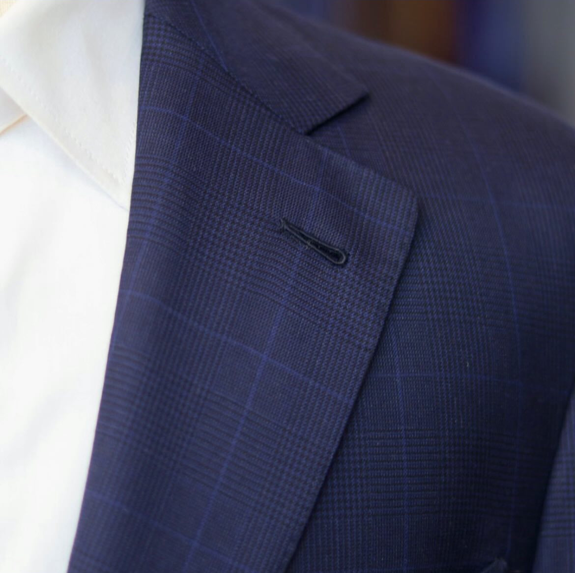 Close-up of a navy Prince of Wales check suit showing the classic layered check and subtle tonal overcheck